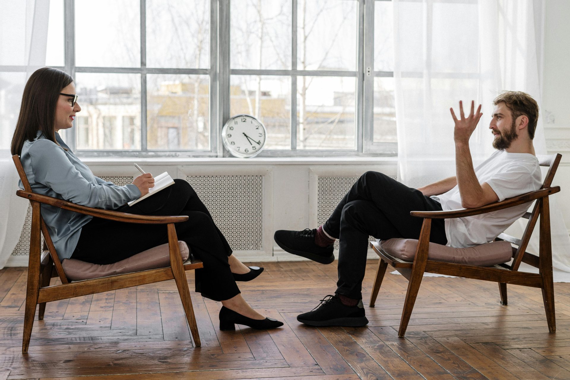 Ein Therapeut führt eine Beratungssitzung mit einem männlichen Patienten durch, um seine psychische Gesundheit zu unterstützen.