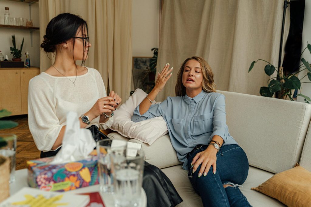 Eine Beratungssitzung mit zwei Frauen, die auf einem bequemen Sofa im Gespräch sind.