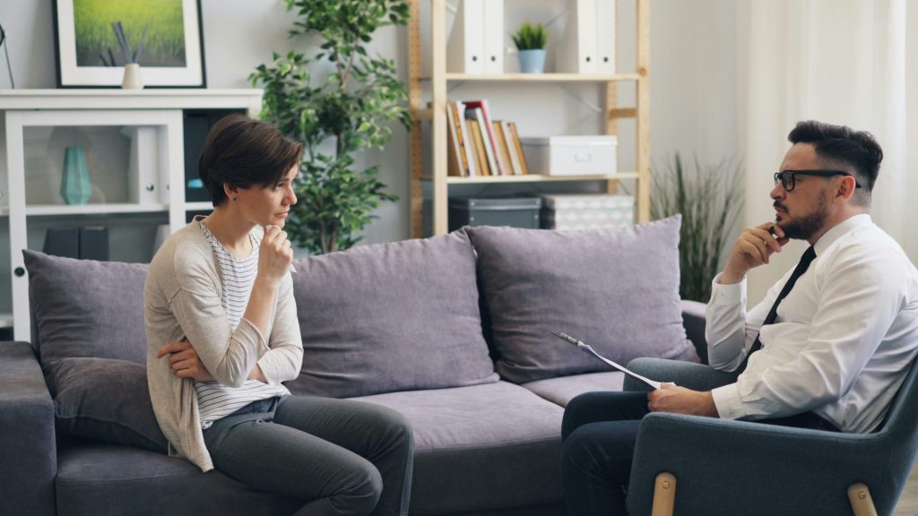 Ein Mann und eine Frau sitzen auf einer Couch und unterhalten sich